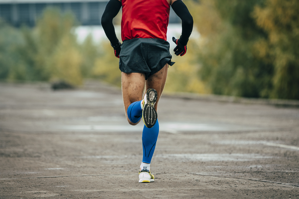 man wearing compression stockings while running and exercising
