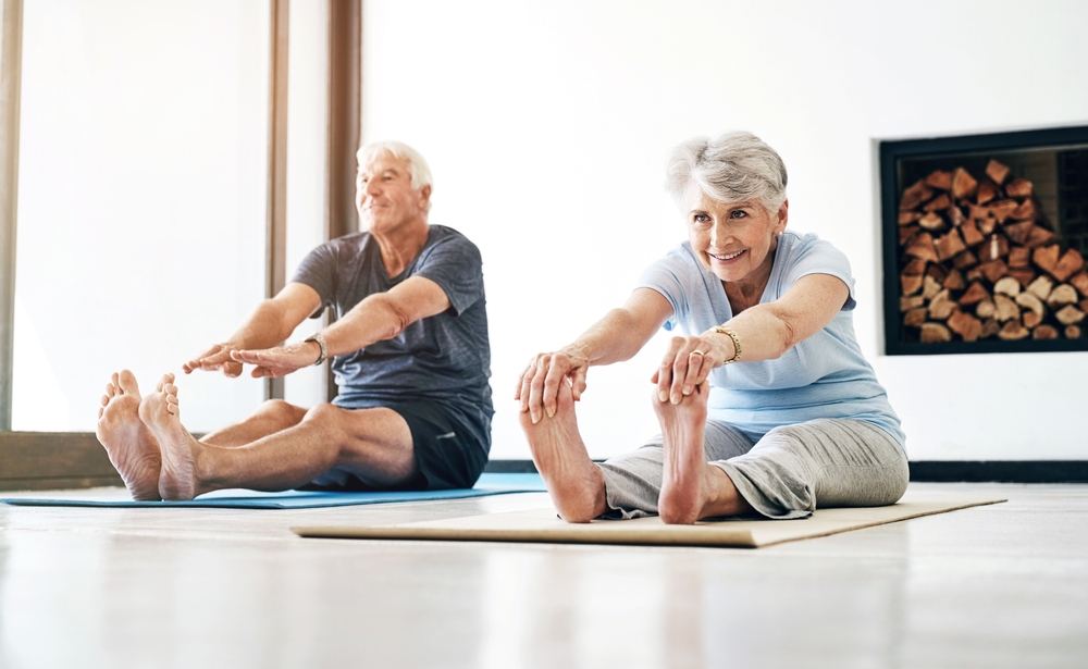 A couple practicing yoga at home.