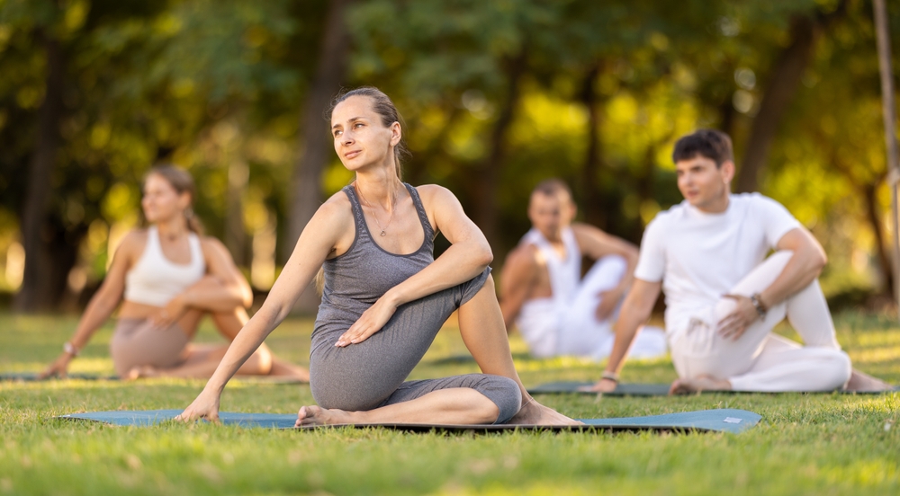 A group doing yoga at a park.