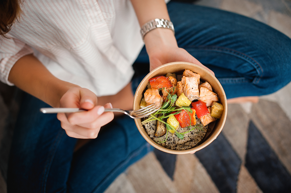 A woman holding a healthy meal.