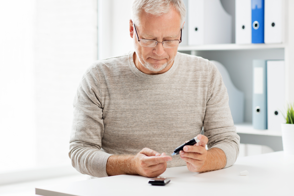 A man with diabetes taking his blood sugar.