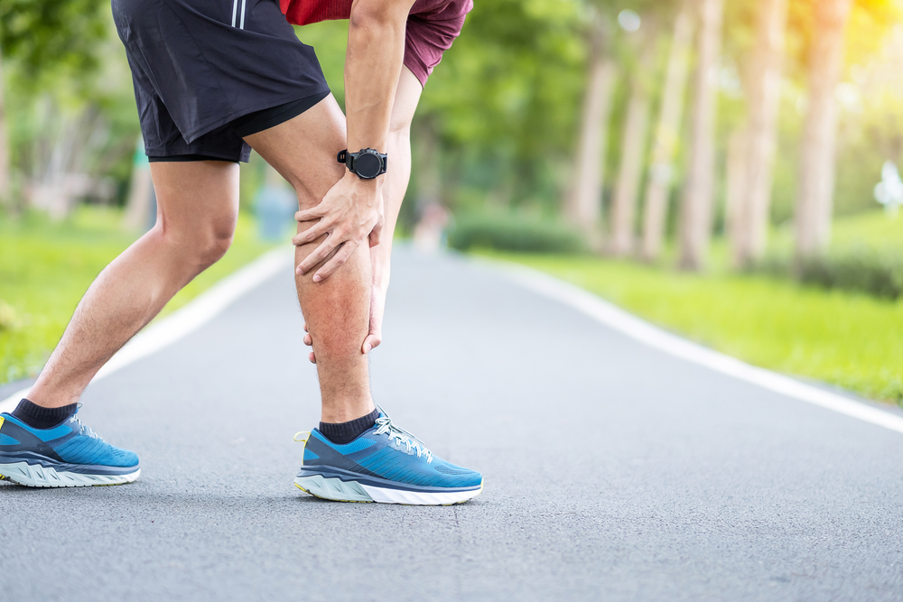 A runner holding his leg in pain.