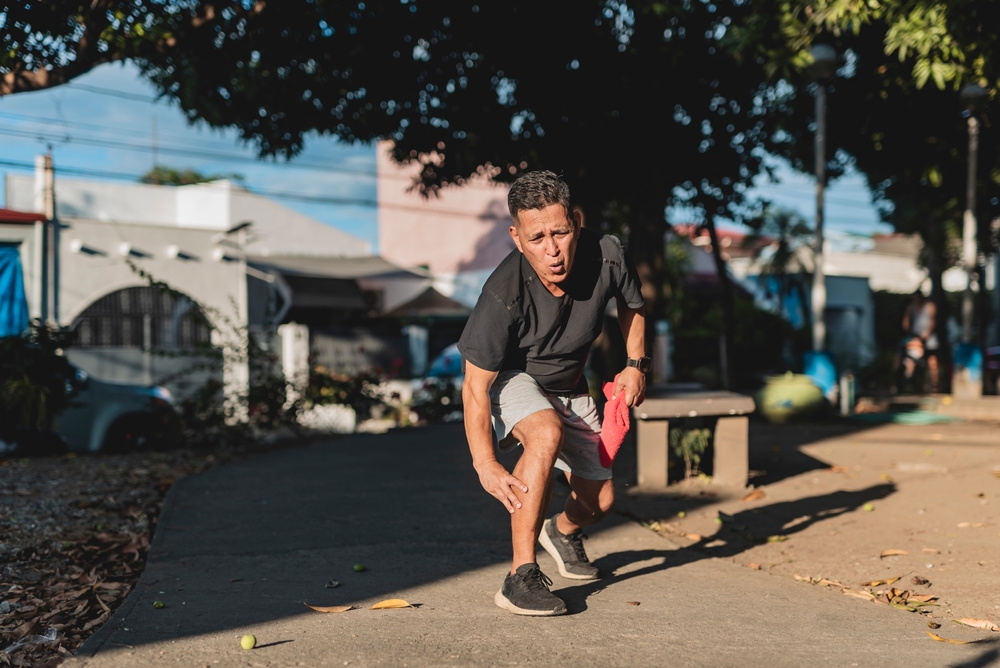 A man grabbing his leg in pain.